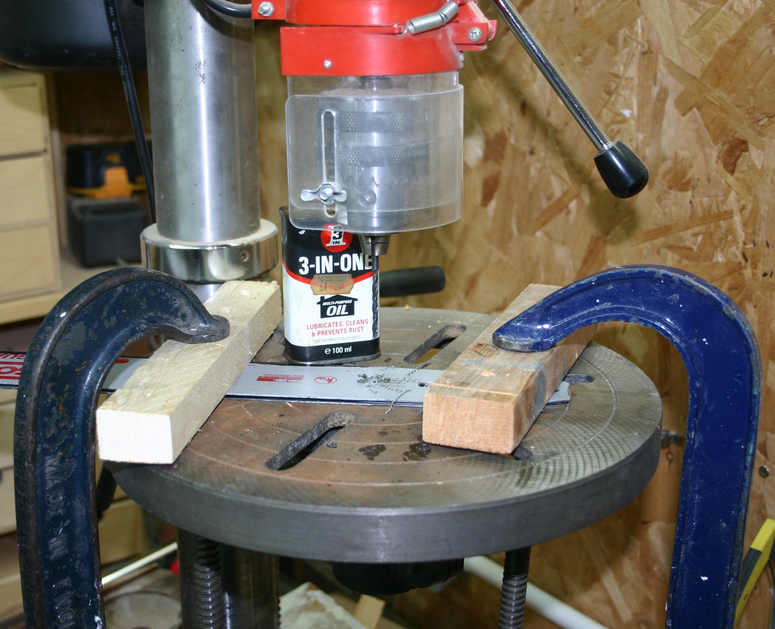 Drilling a rear bolting hole in the chainsaw guide bar.