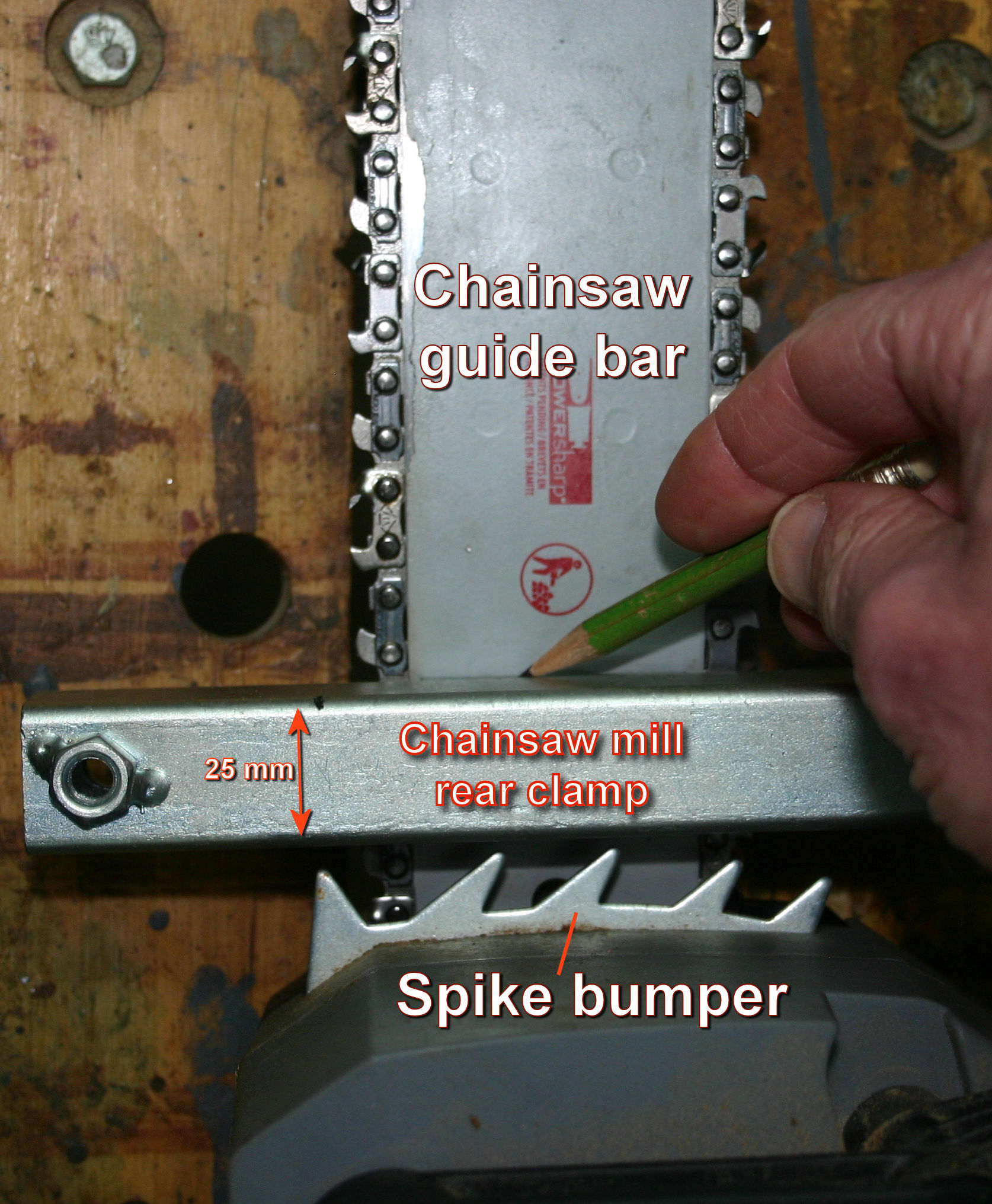 Marking the position of a rear bolting hole in a chainsaw guide bar.