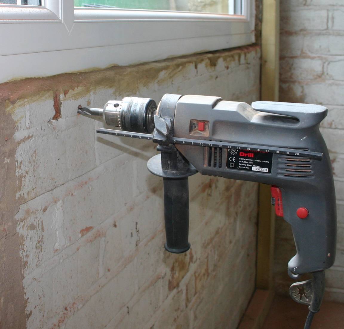 Enlarging the 5mm pilot hole with masonry drills to 10mm diameter.