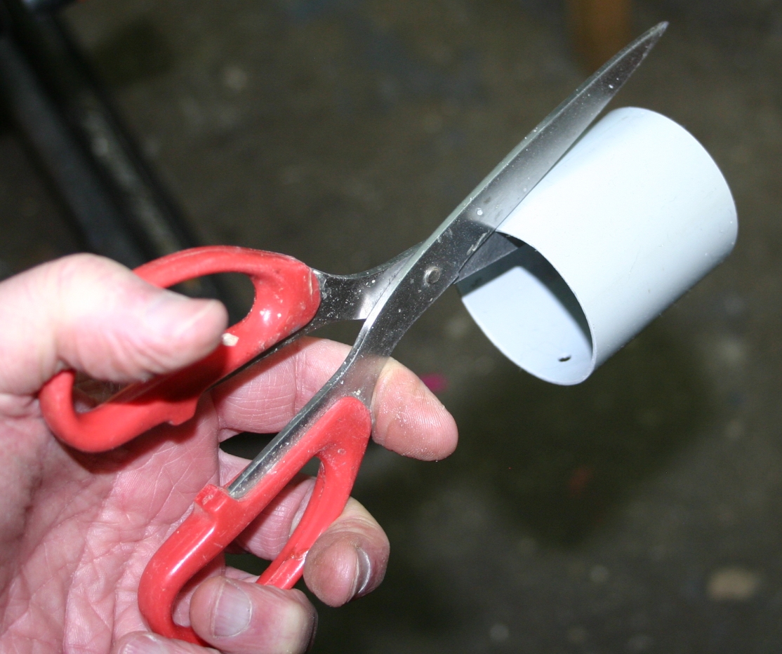 Cutting a slit in the Plastic Pipe.