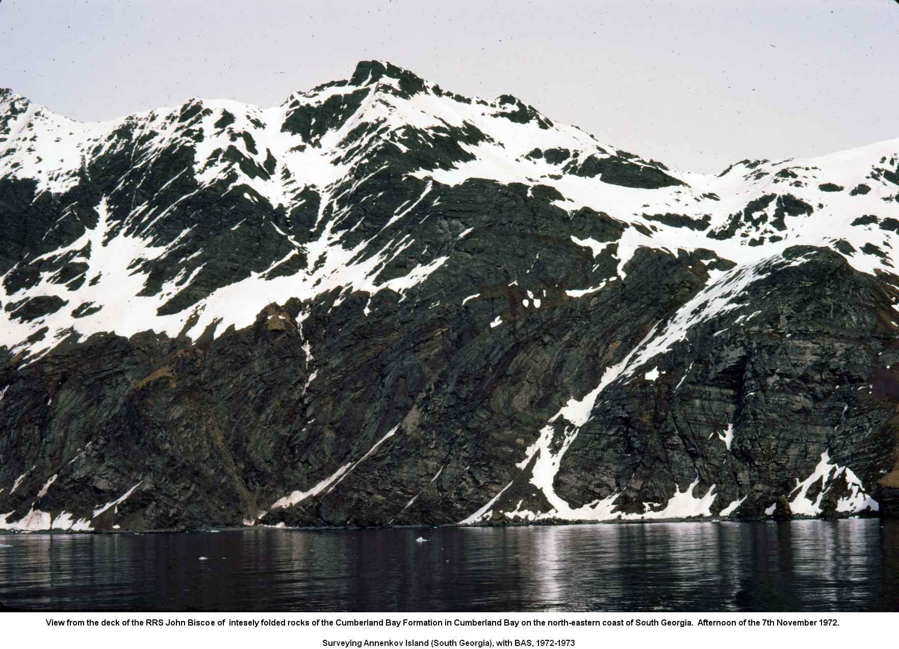 View from the deck of the RRS John Biscoe of intesely folded rocks of the Cumberland Bay Formation in Cumberland Bay on the north-eastern coast of South Georgia.  Afternoon of the 7th November 1972