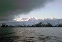 View from the deck of the RRS John Biscoe, looking north-east at the sun-lit peaks of South Georgia, at Queen Maud Bay on the evening of 13th November 1972.