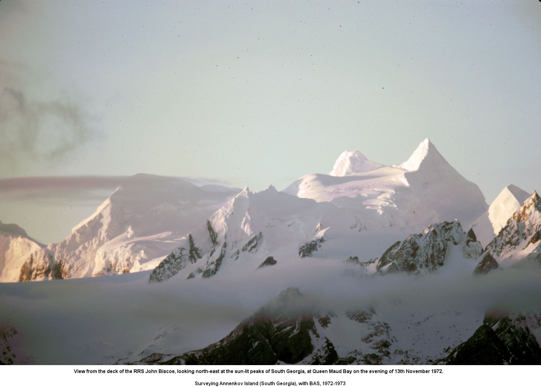 View from the deck of the RRS John Biscoe, looking north-east at the sun-lit peaks of South Georgia, at Queen Maud Bay on the evening of 13th November 1972.